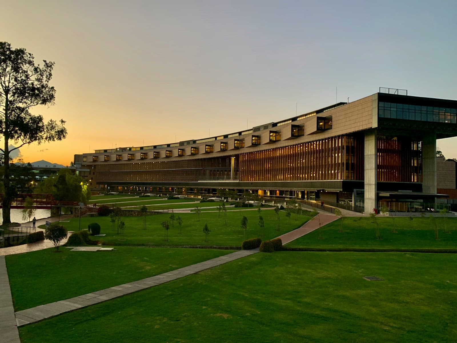 A low brick building beside a lawn under an evening sky